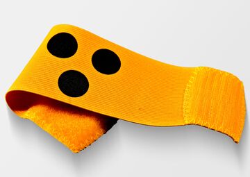 Ansicht auf die gelbe Armbinde mit drei schwarzen Punkten.