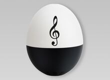 Ansicht auf ein PiepEi in weißer und schwarzer Farbe mit einem Notenschlüssel