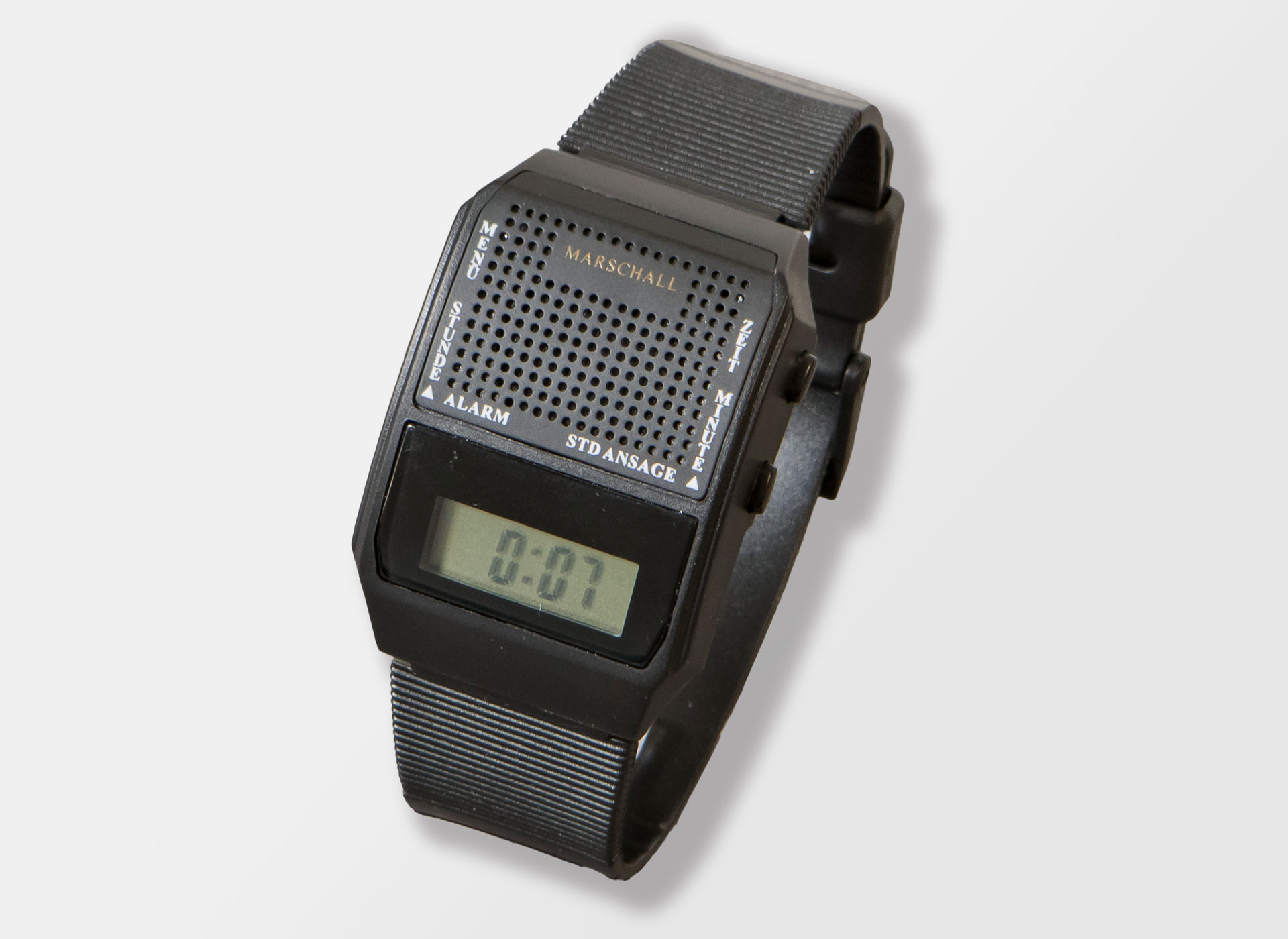 Ansicht auf die schwarze Uhr mit Display in einem transparenten Ständer.