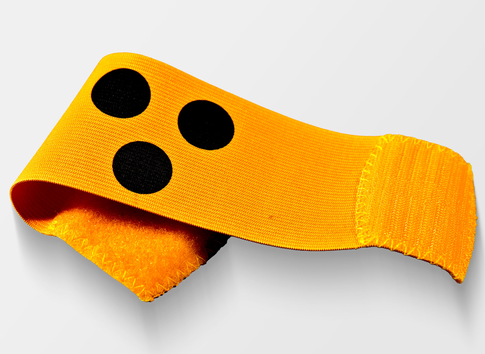 Ansicht auf die gelbe Armbinde mit drei schwarzen Punkten.