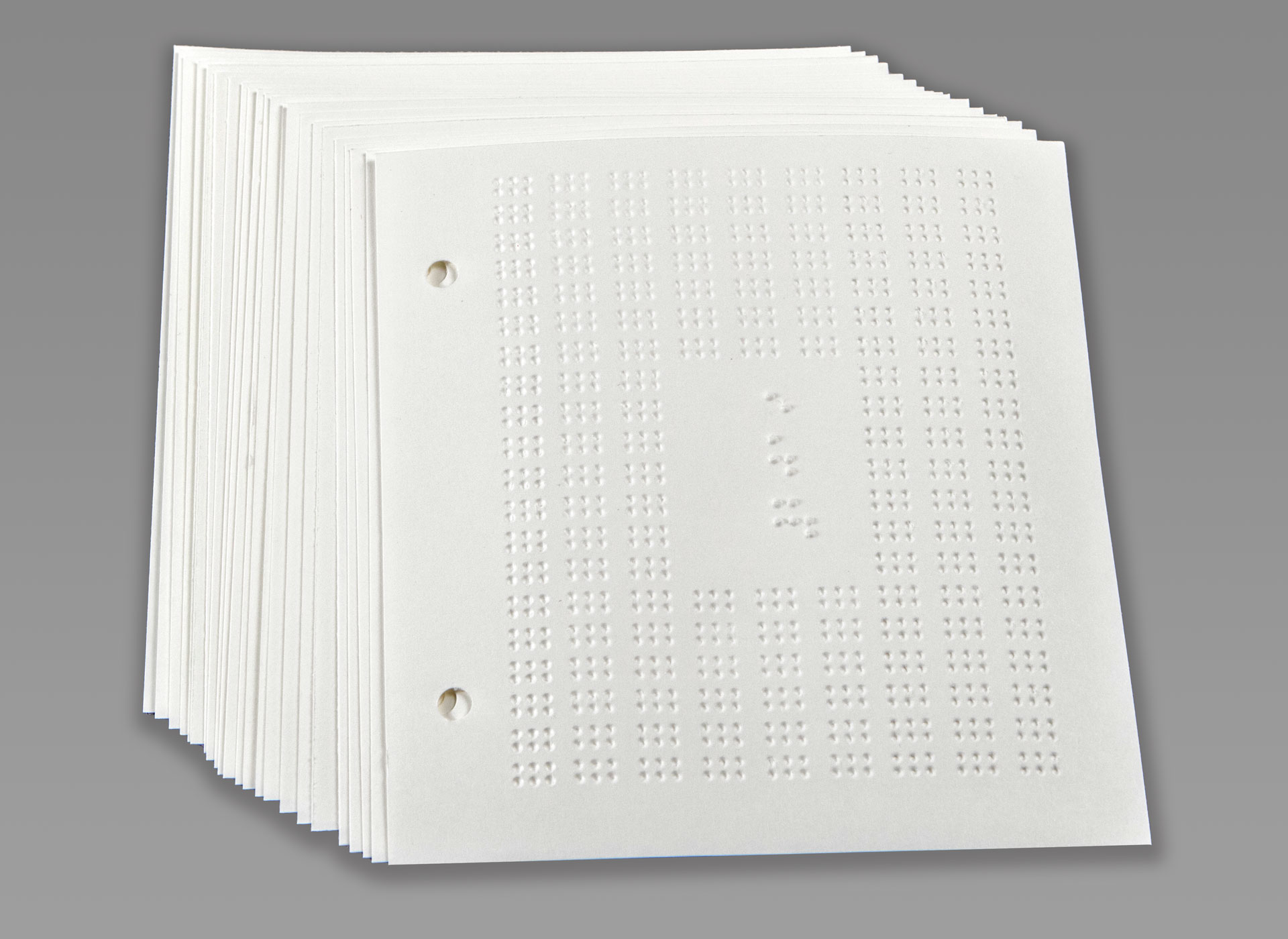 Ansicht auf das weiße Braille-Papier mit Lochung.