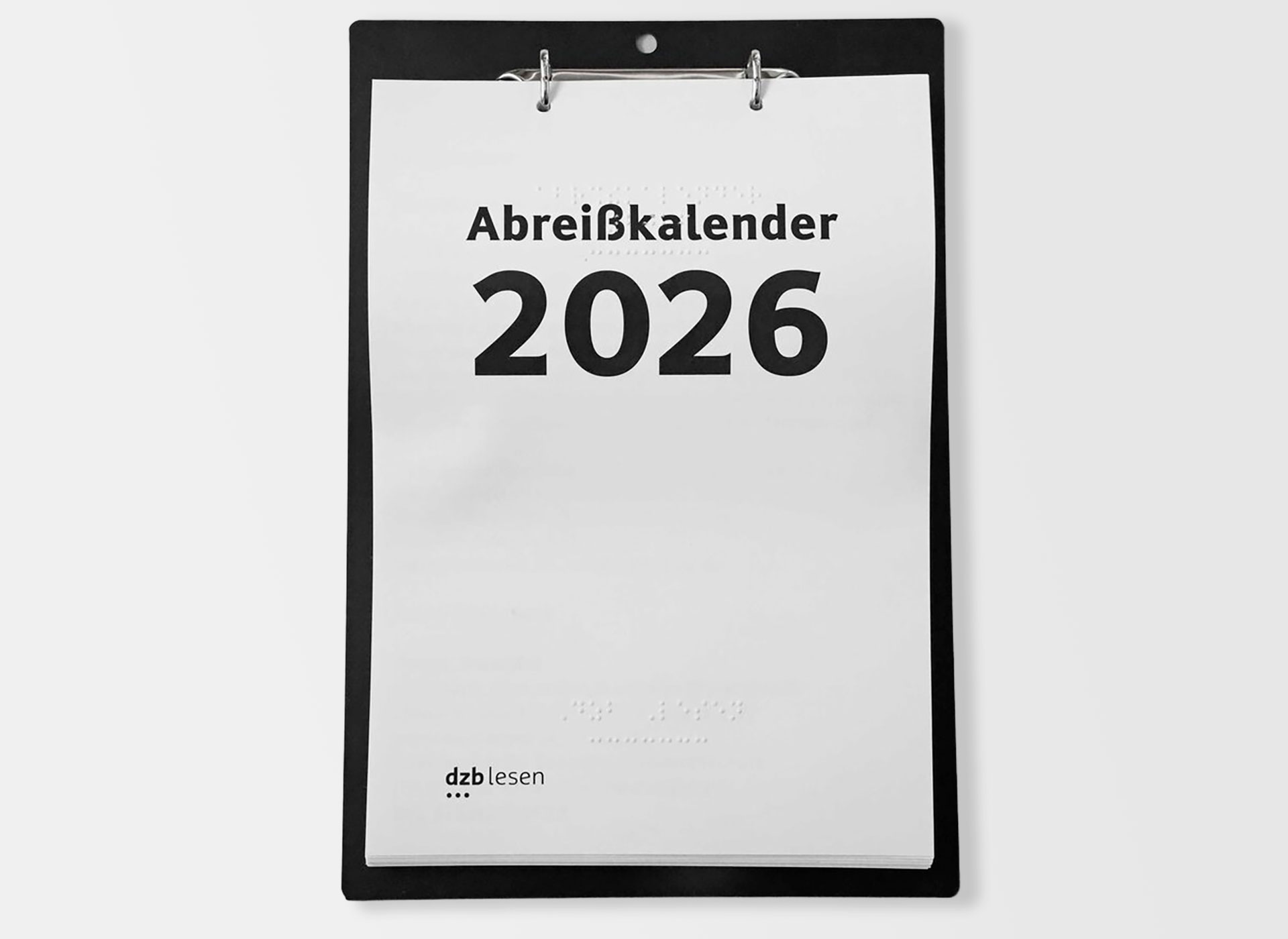 Ansicht auf einen Kalender mit Brailleschrift auf einer Aufhängung mit Ringlochung 